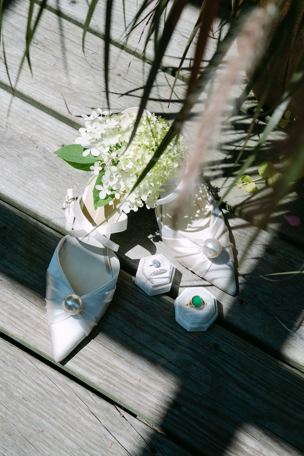 Delicate white flowers cast shadows on a light wooden surface in an artistic arrangement.