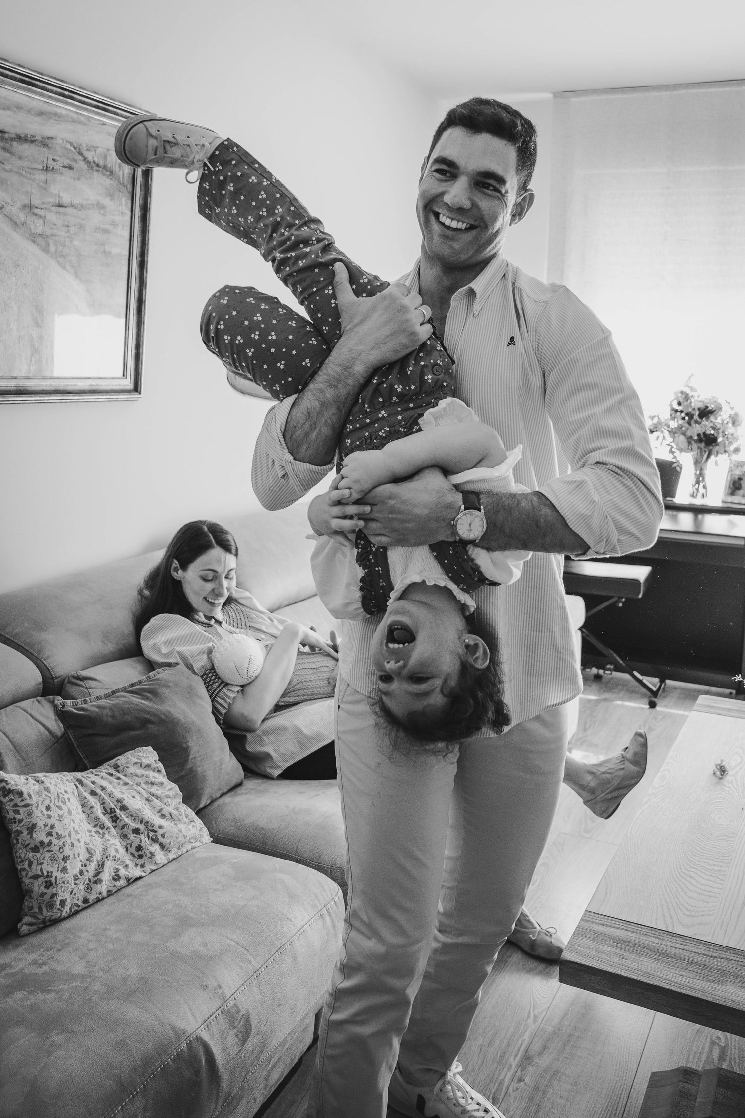 A heartwarming series of black and white photos showing tender family moments on a couch with a baby.