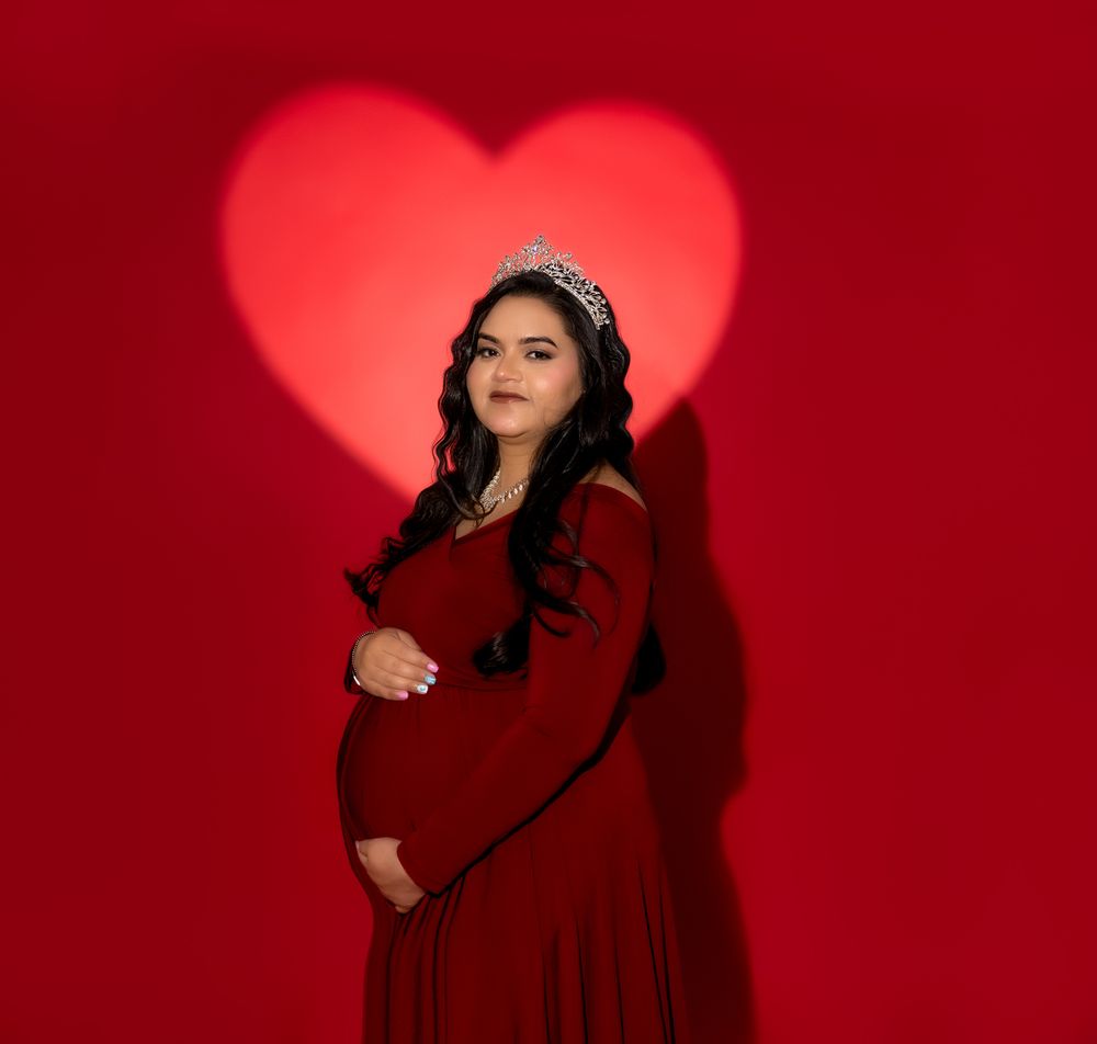 Fashion portraits against red background featuring romantic heart-shaped lighting and dramatic poses in matching burgundy outfit.