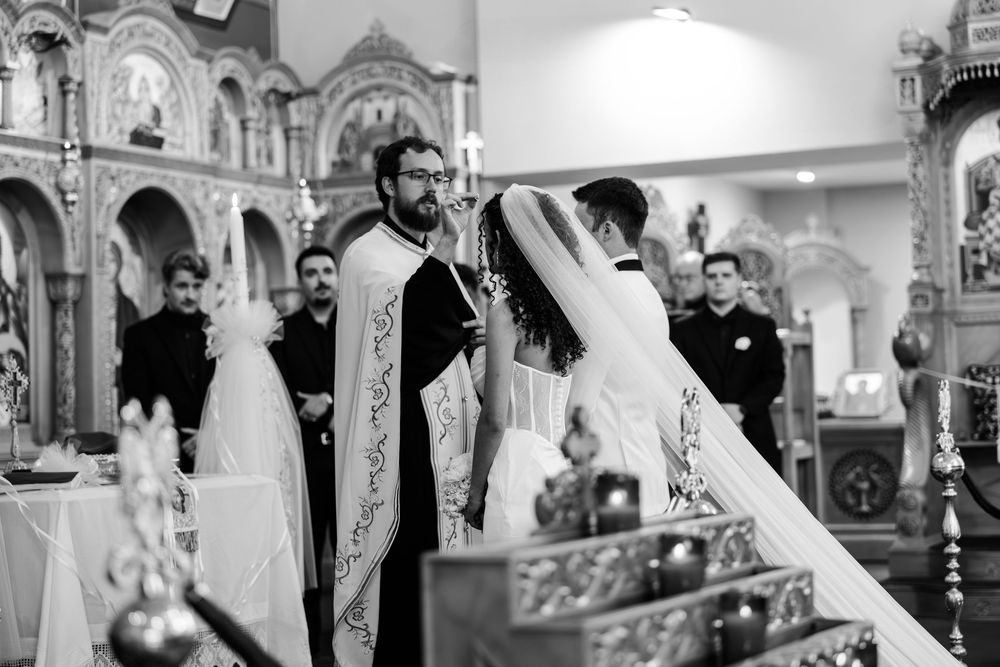 Medieval dancers perform in traditional costumes at an elaborate church ceremony in black and white photography.
