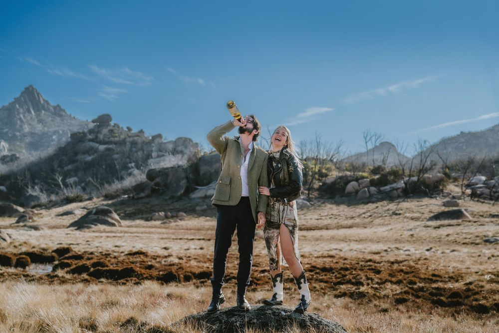 A couple walks together through scenic mountain landscapes in the Dolomites during an engagement photo session.