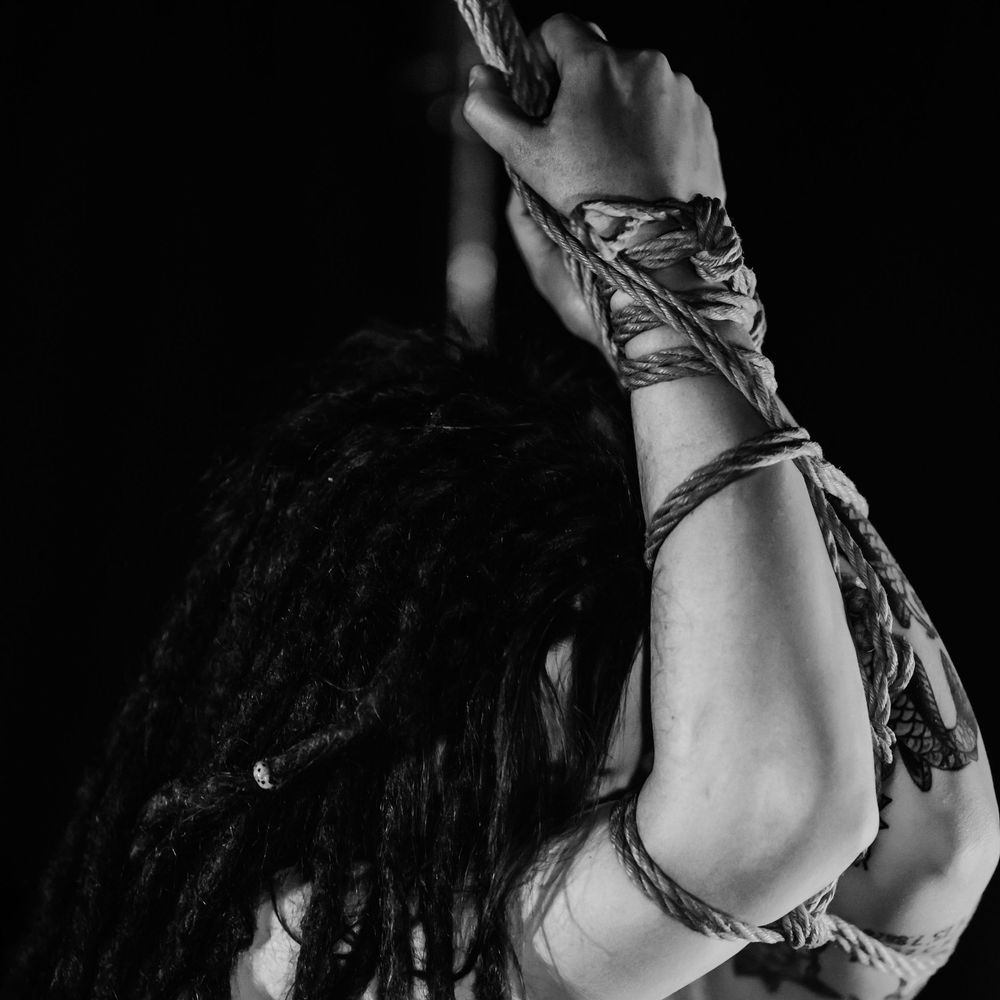 Close-up sequence of black and white photos showing someone with dreadlocks and gold jewelry in artistic poses.