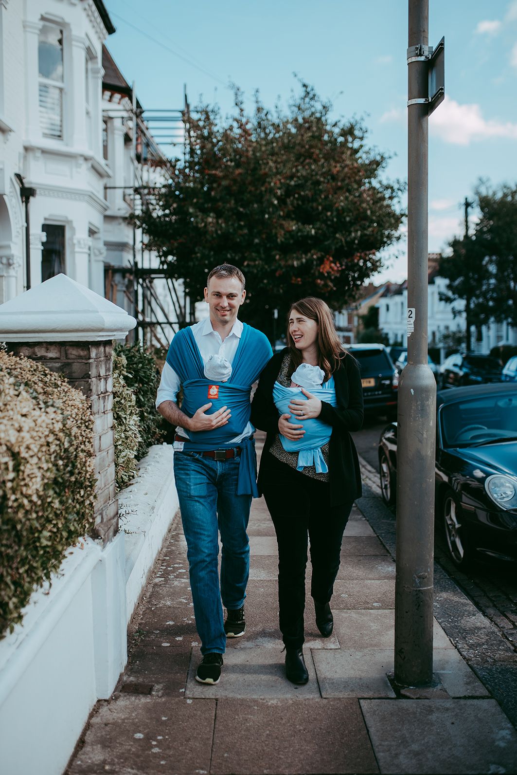 A couple walks together on a sidewalk past a white wall in a series of progressive photos.