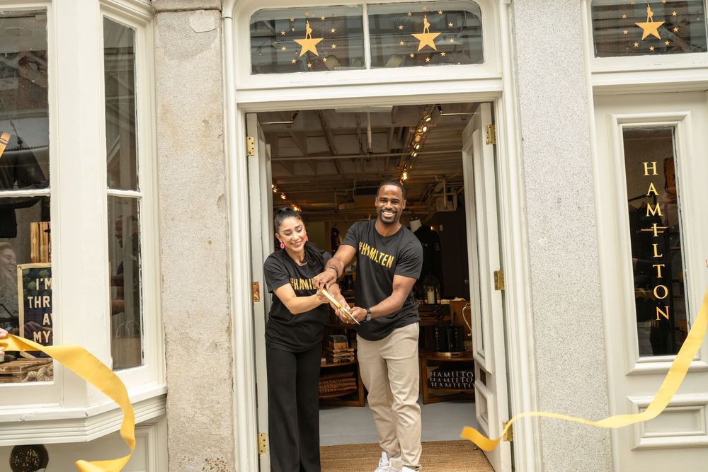 Two people standing in doorway of shop with star decorations and yellow accents.