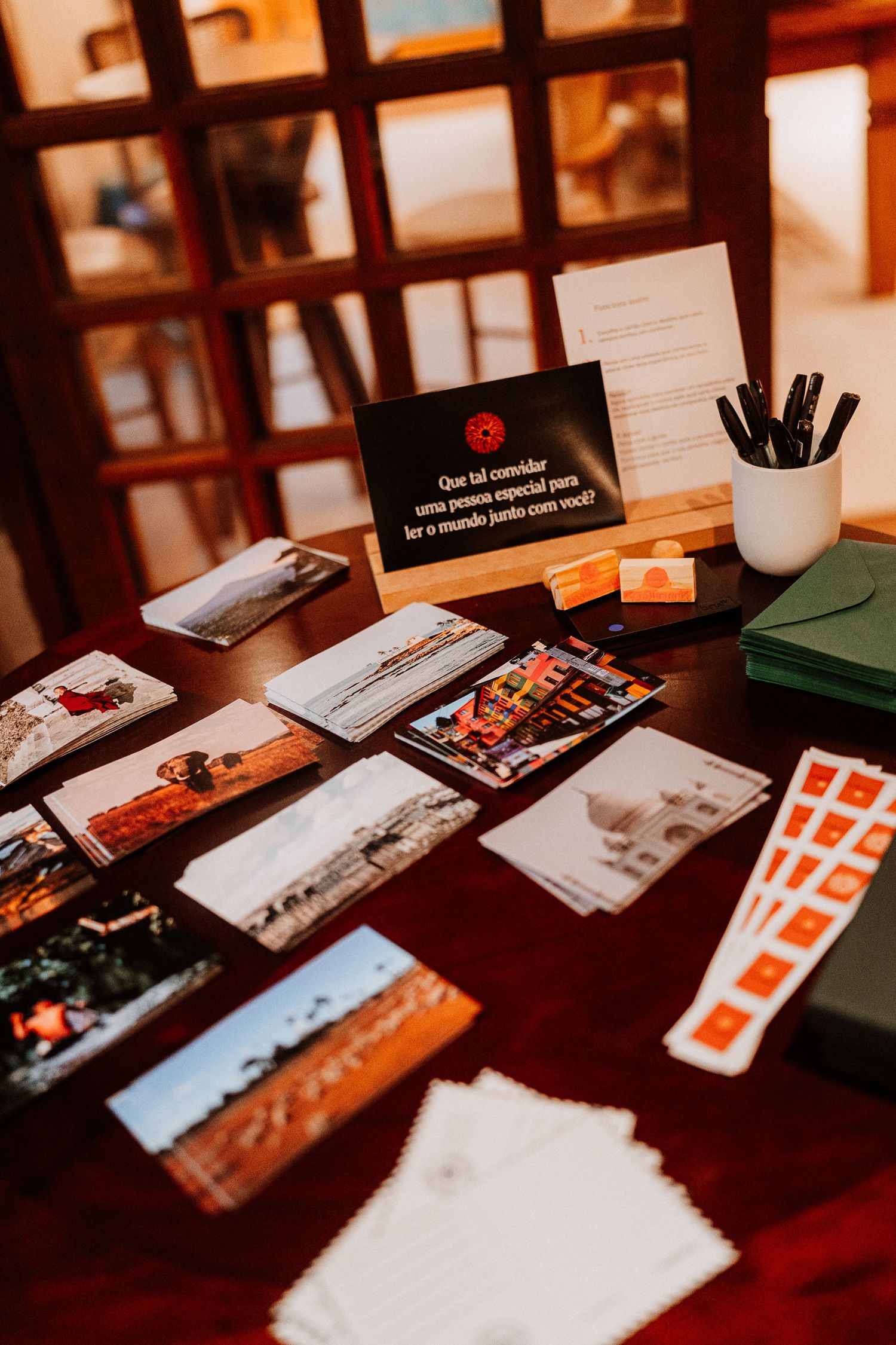 Table arrangement of photos, cards and stationery materials in warm lighting.