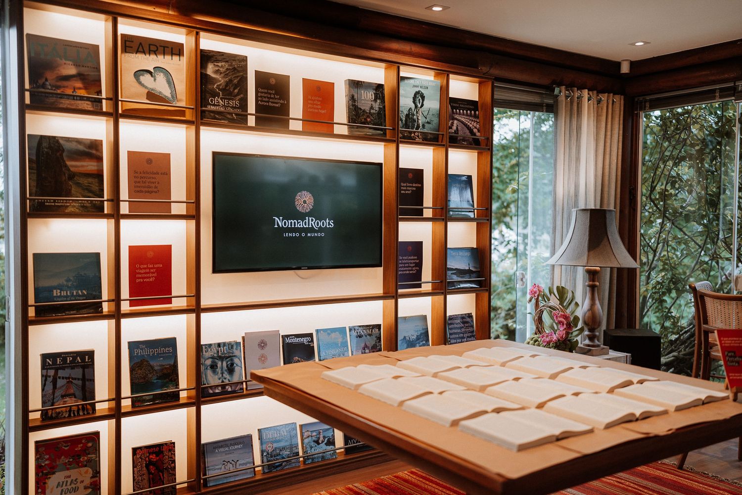 Modern display wall with built-in shelving, TV screen and wooden table in an elegant setting.