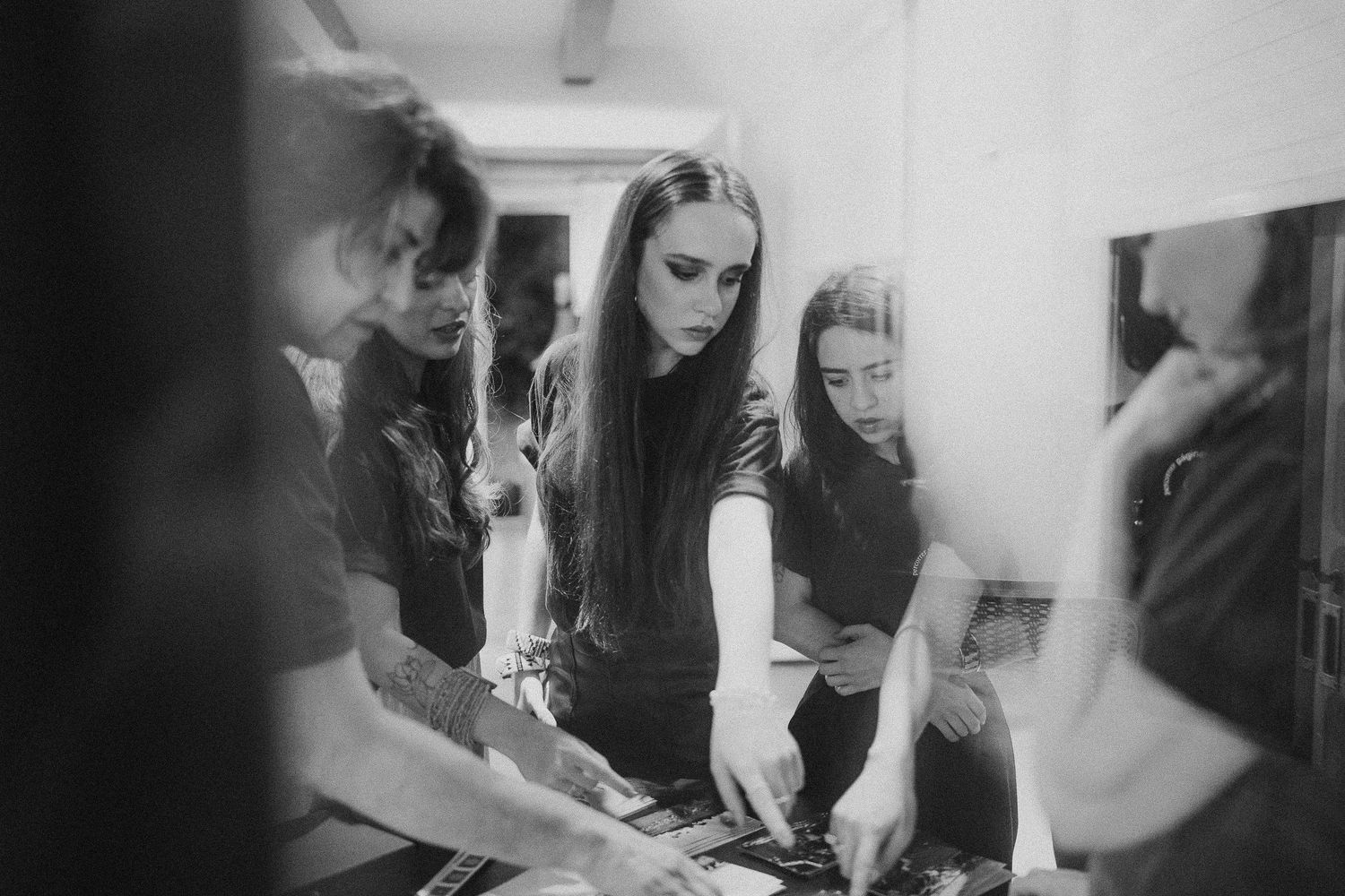 Black and white image of people collaborating in workshop setting.
