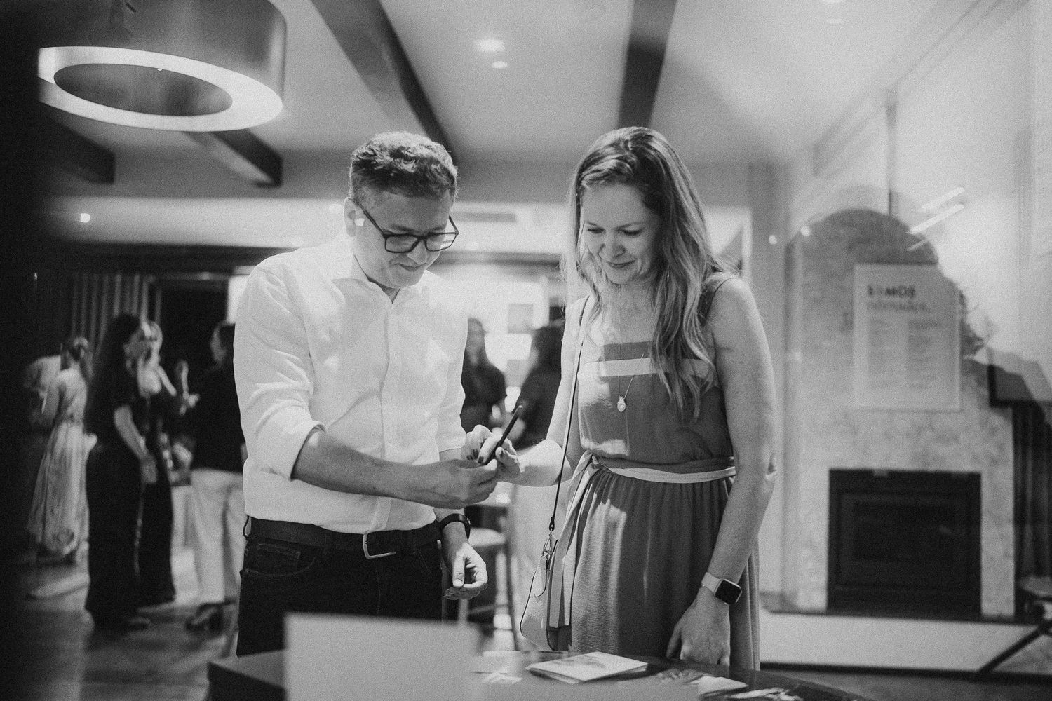 Black and white photos of people interacting in indoor event space.