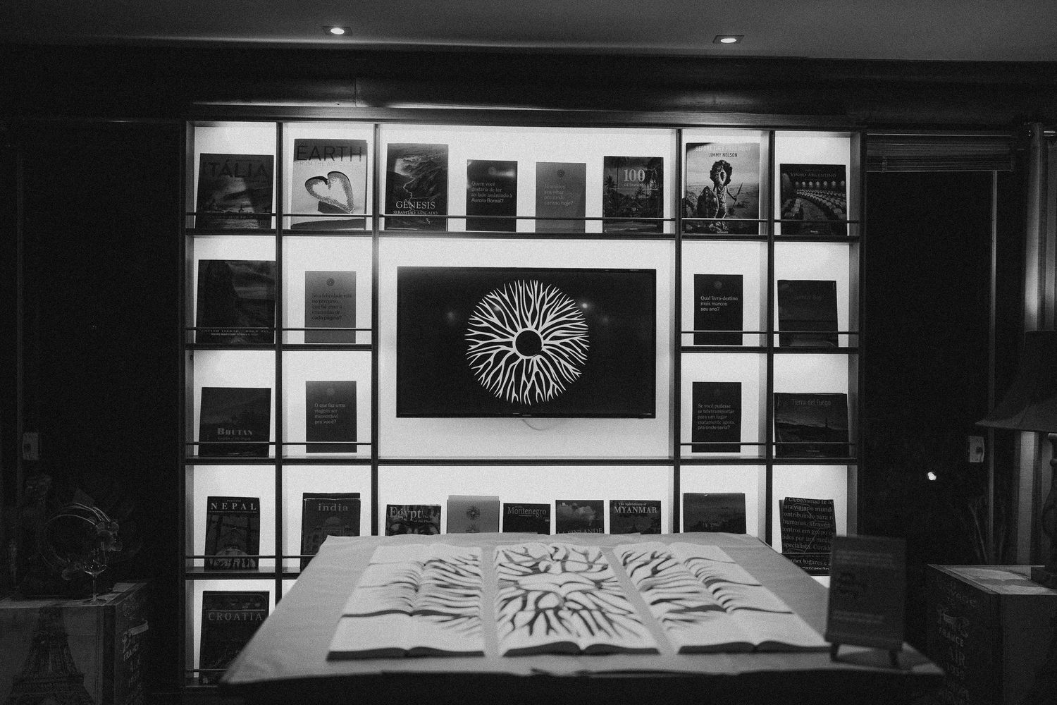 Black and white photo of illuminated built-in shelving with circular art display.