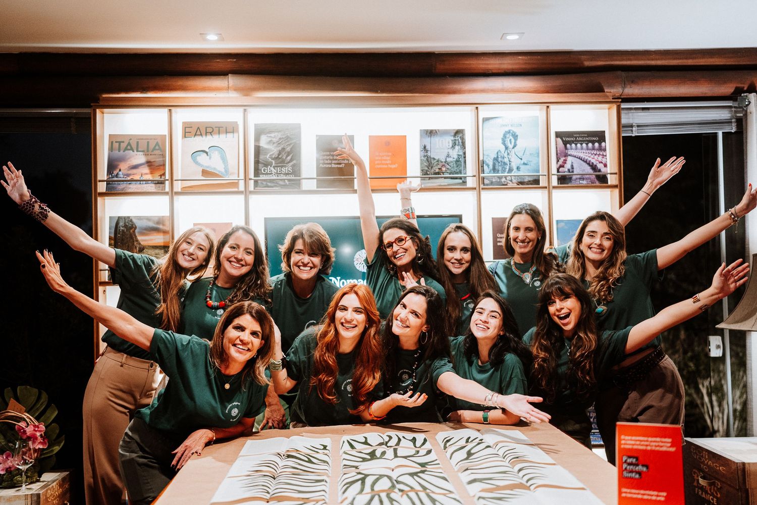 Group photo of people celebrating around a decorated table with arms raised in joy.