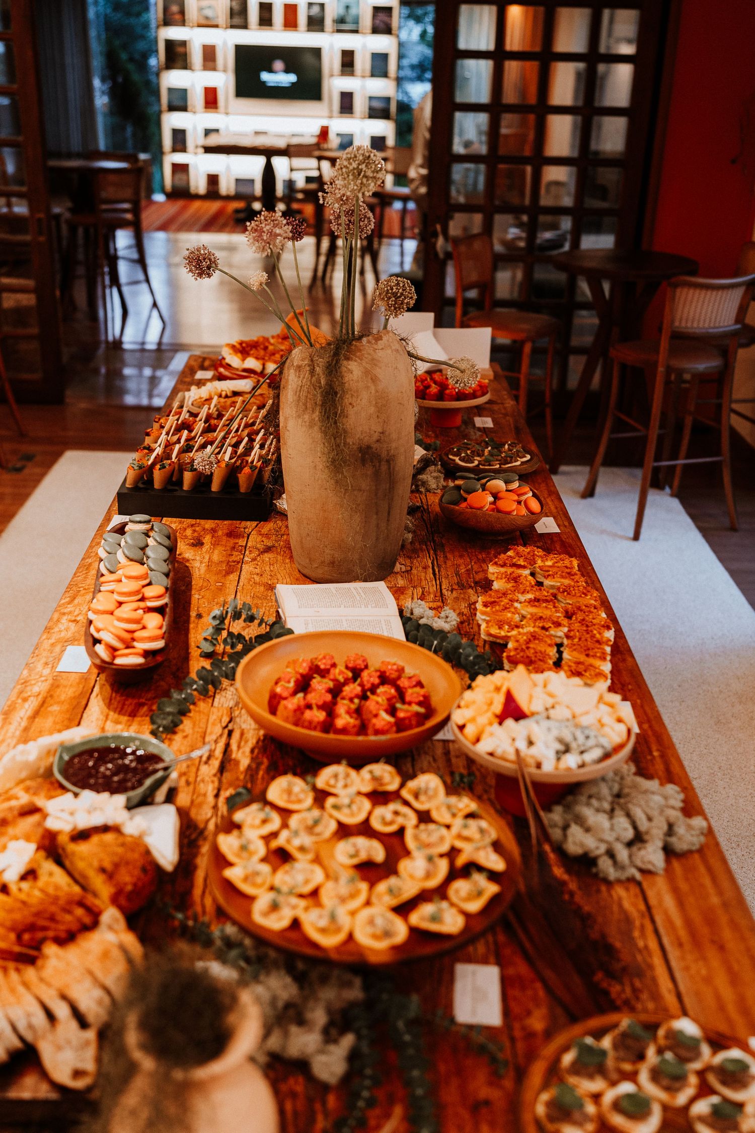 Wooden table spread with various appetizers and snacks for a catered event.