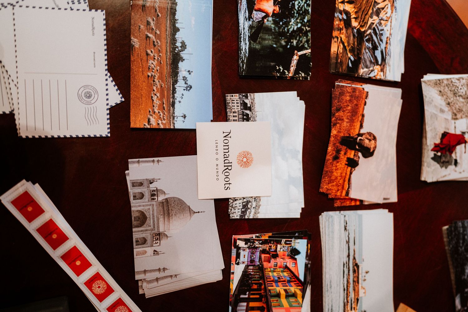 Flat lay of postcards and travel memorabilia arranged on dark wooden surface.