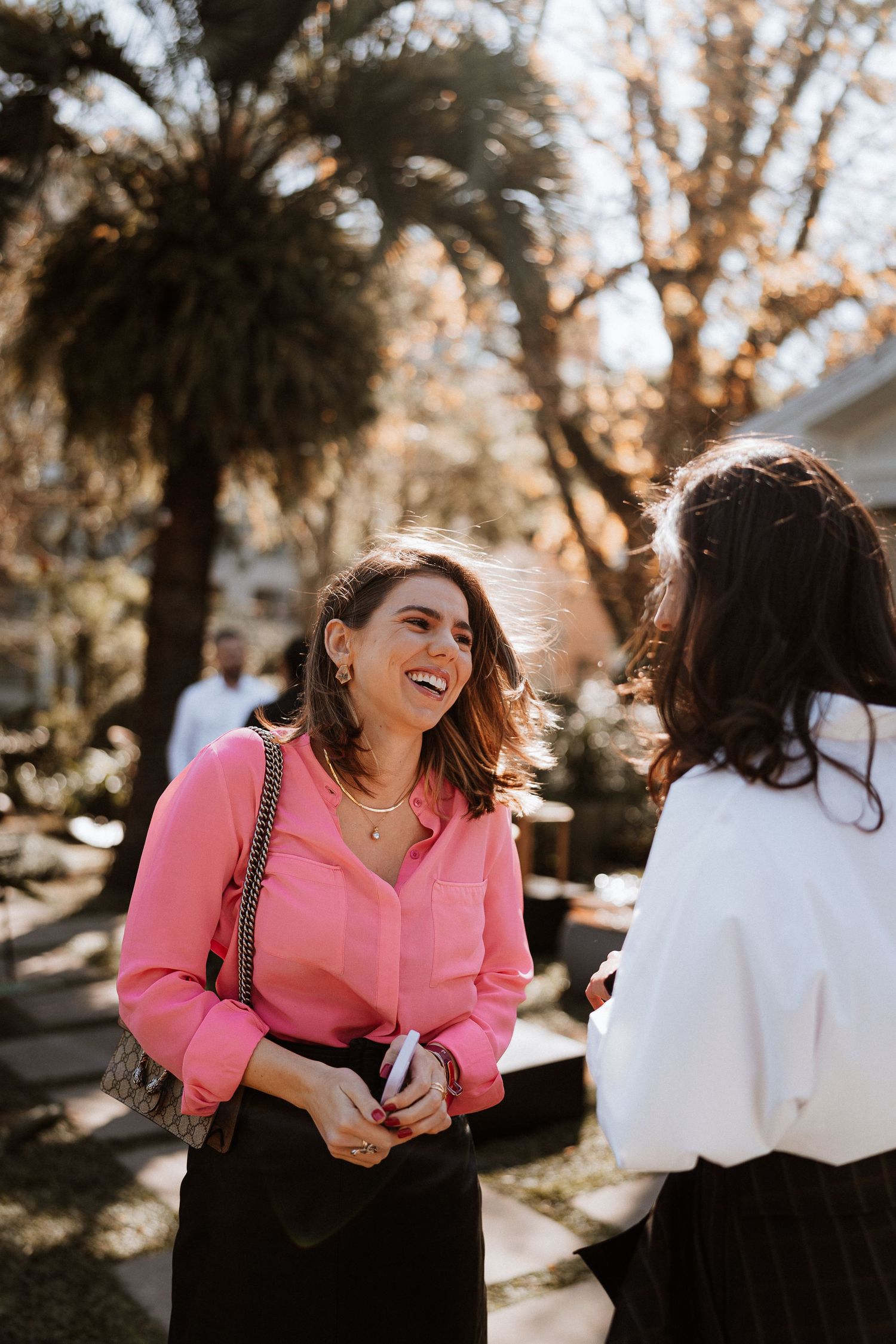 Two people sharing a joyful moment outdoors on a sunny day.
