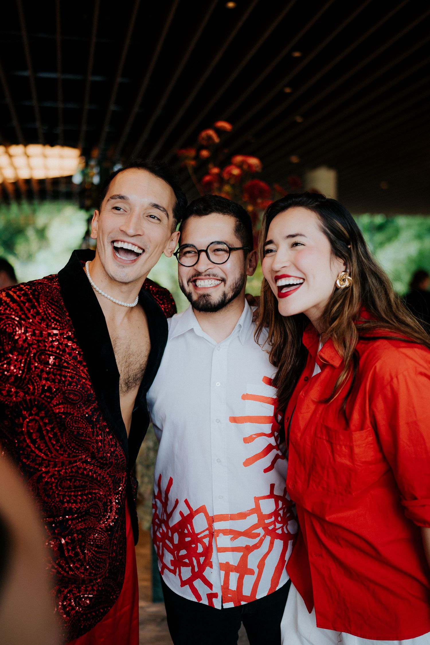 A celebratory moment with people wearing red and sparkly attire at an indoor gathering.