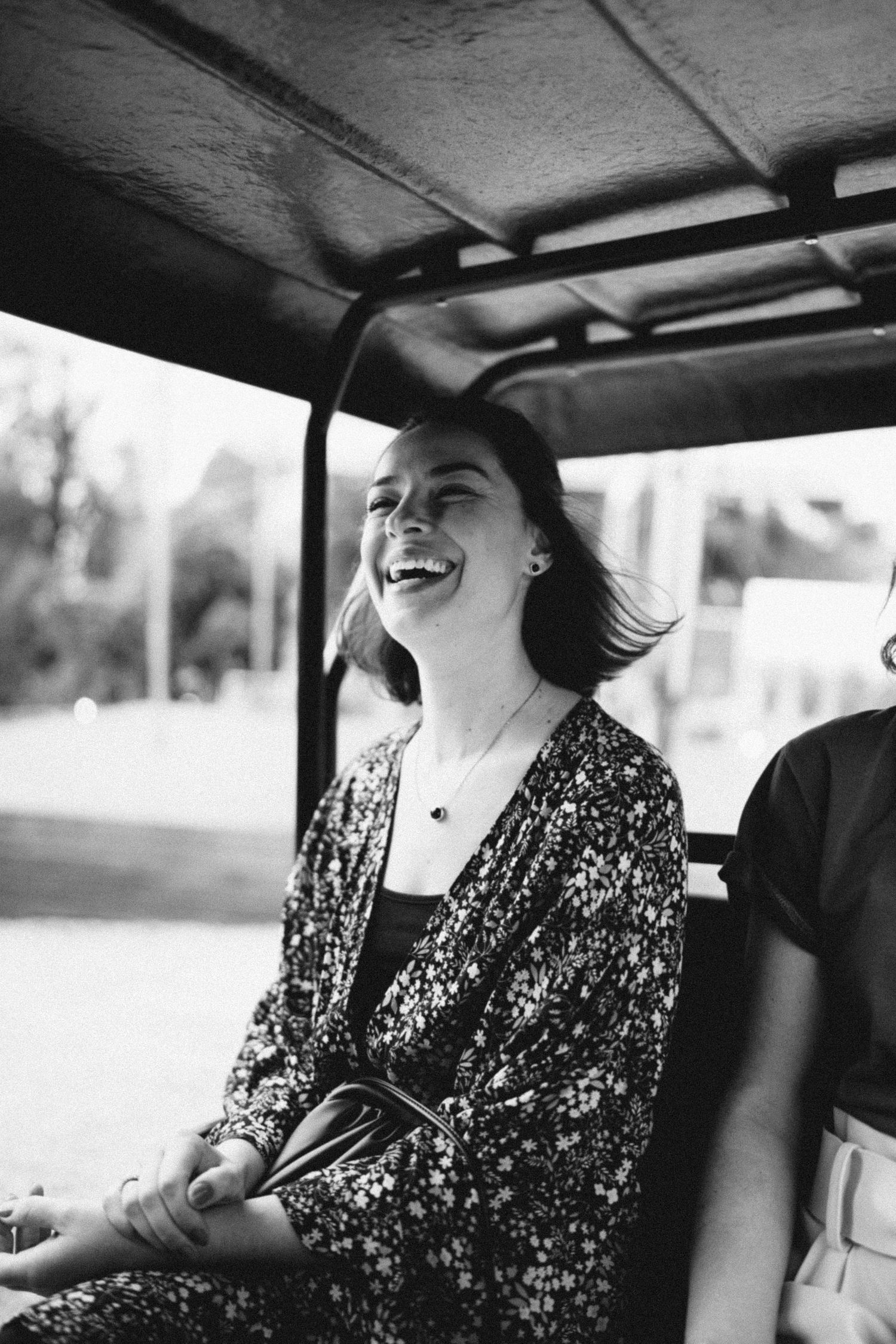 Black and white photograph of passengers enjoying a ride in a vintage car.