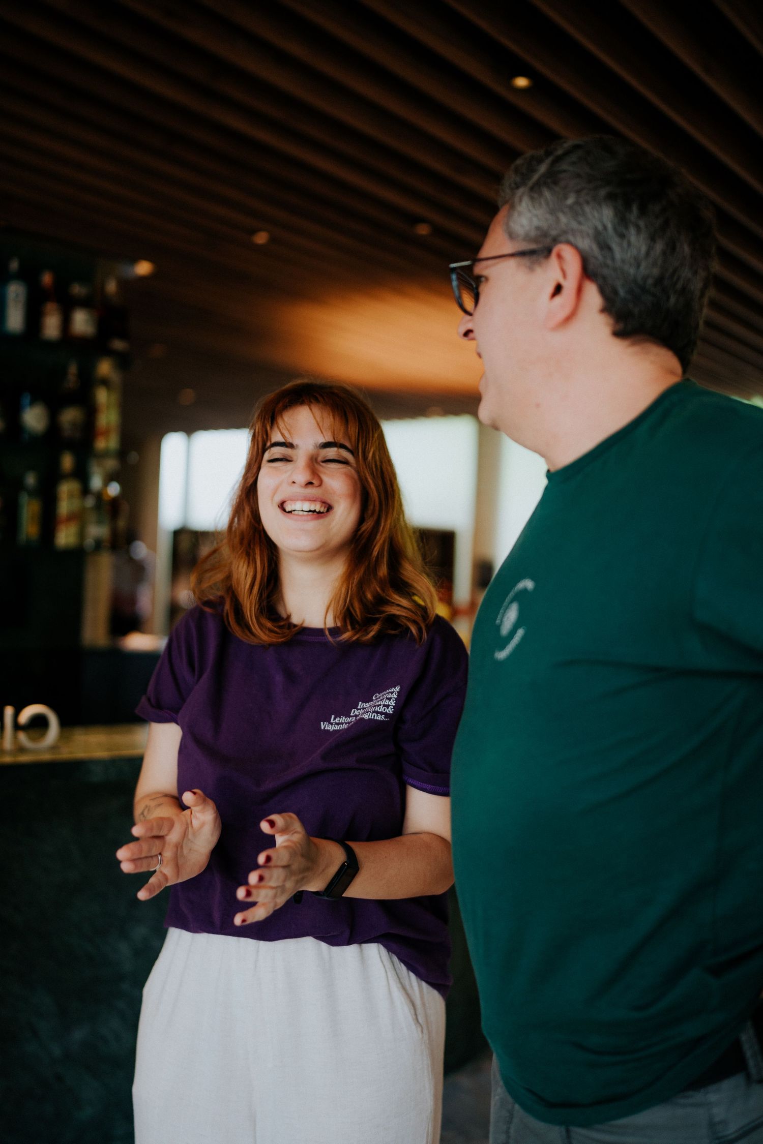 Two people sharing a joyful conversation in a restaurant setting.