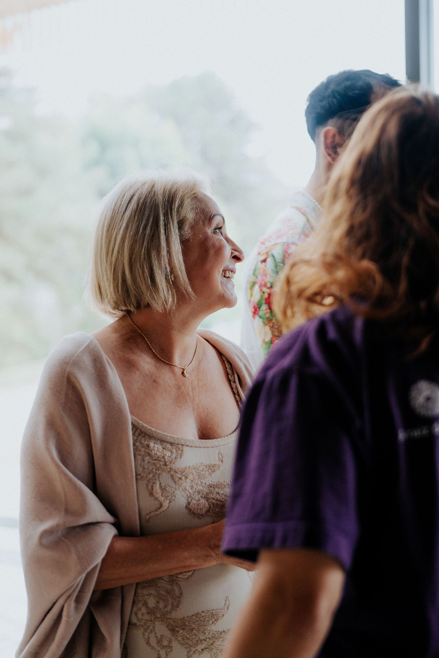 Group of people sharing joyful moment together by window.