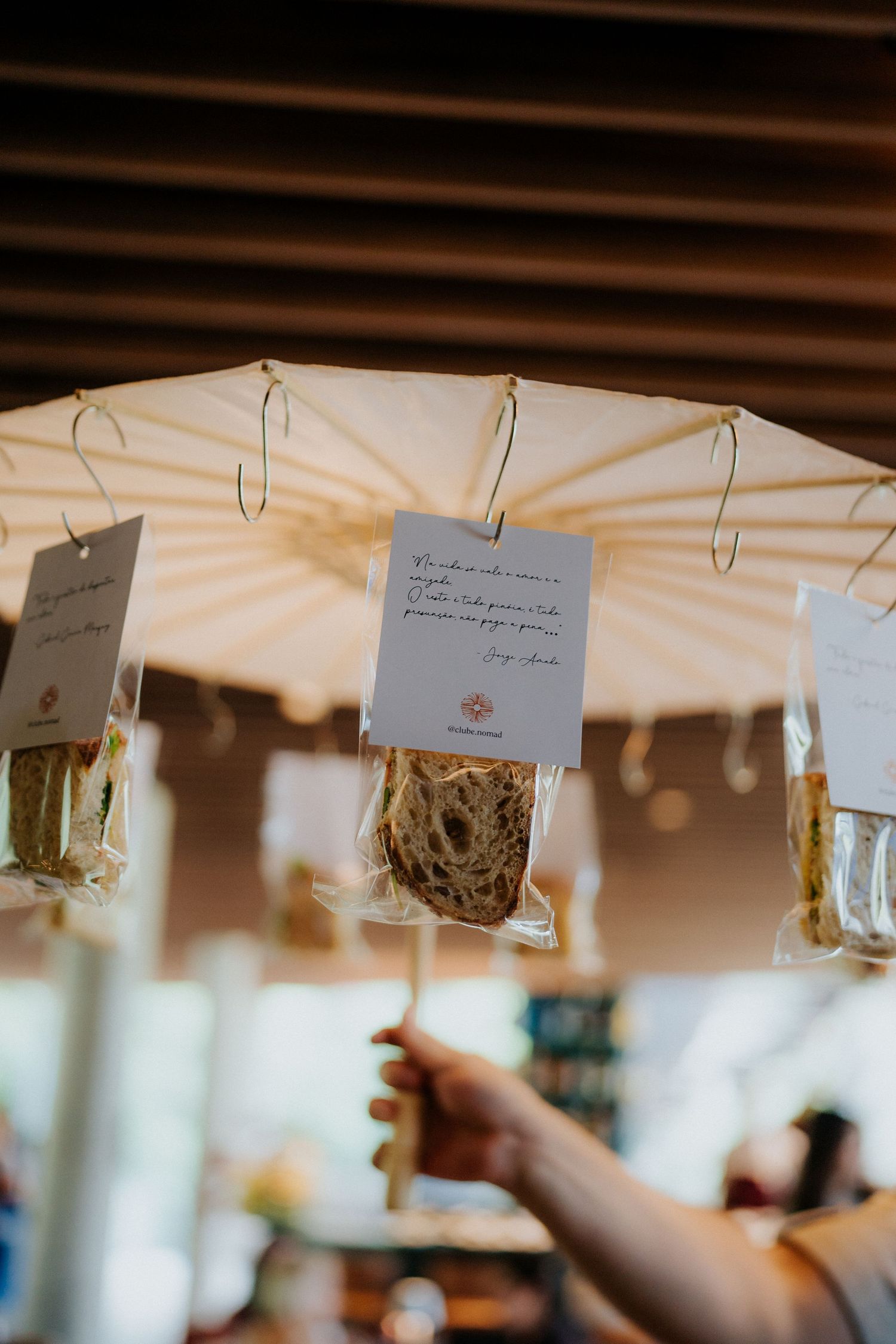 Decorative hanging cards with handwritten notes attached to white umbrella display.