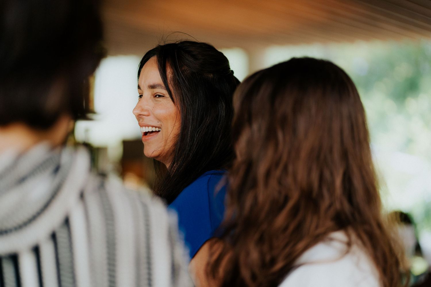 Candid moment of laughter during social gathering indoors.