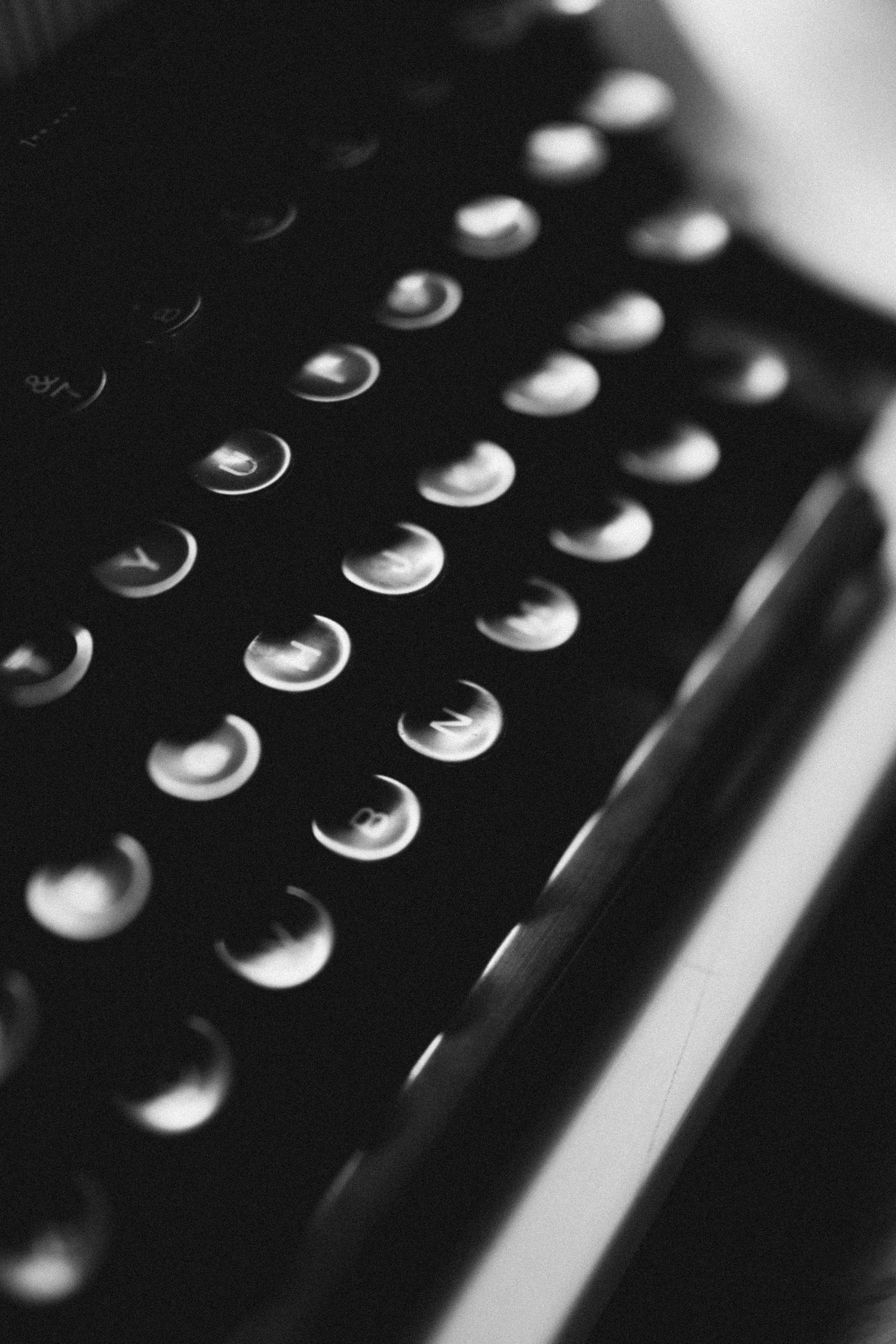 Abstract black and white macro photography of circular metallic buttons in sequence.
