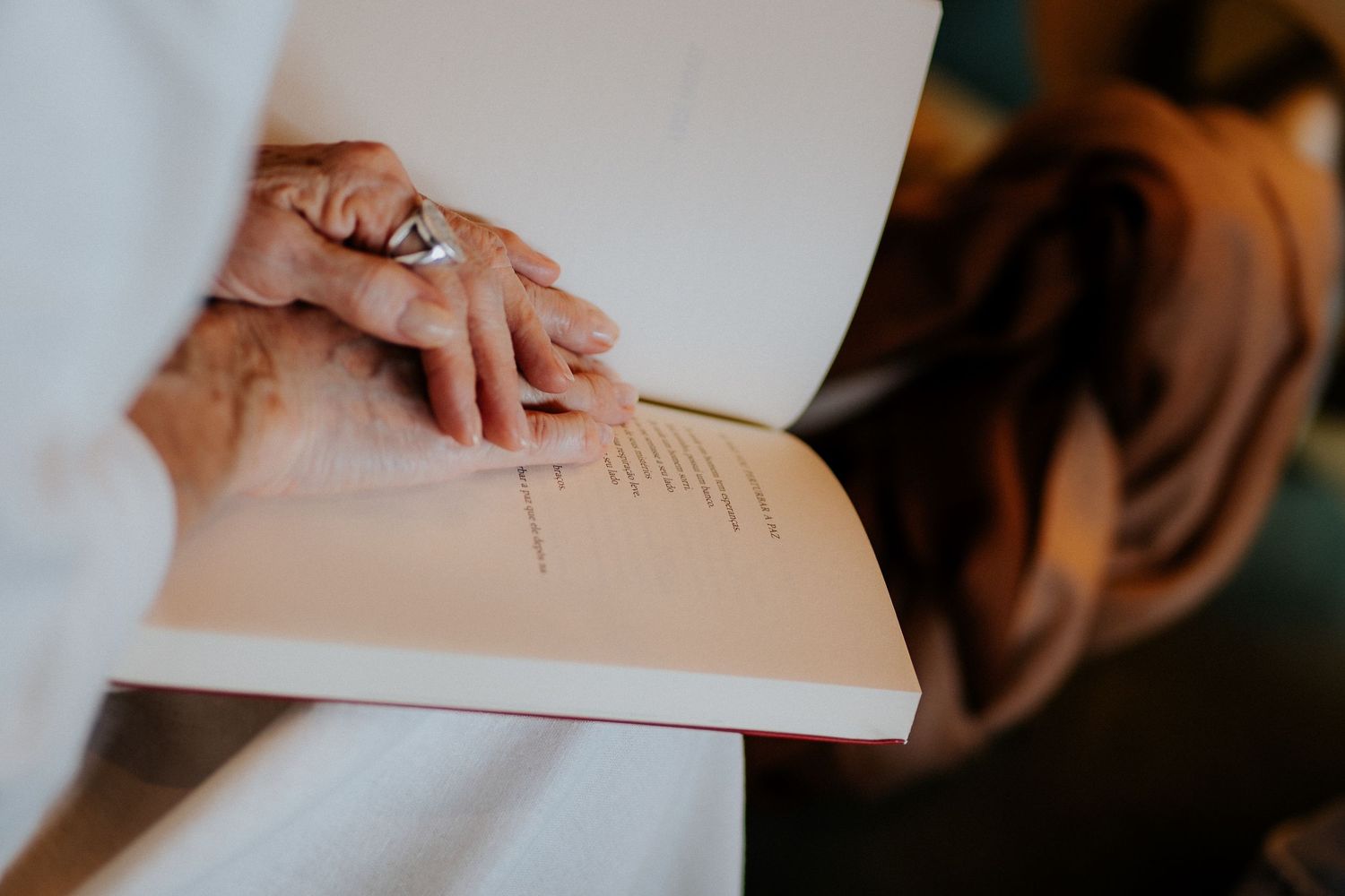Hands resting on an open blank white notebook or journal page.