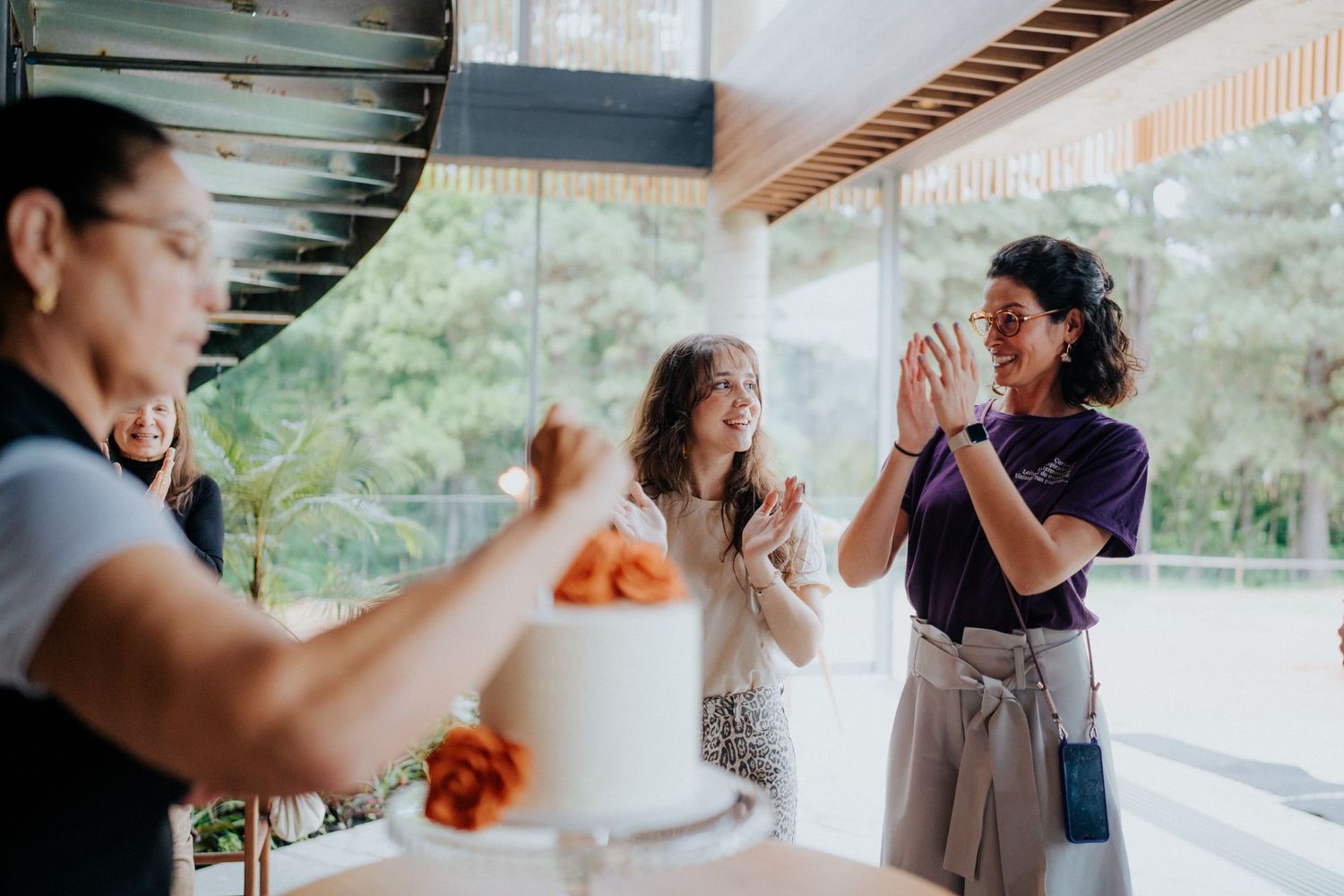Friends sharing an energetic moment of laughter and gestures during a casual indoor meetup.