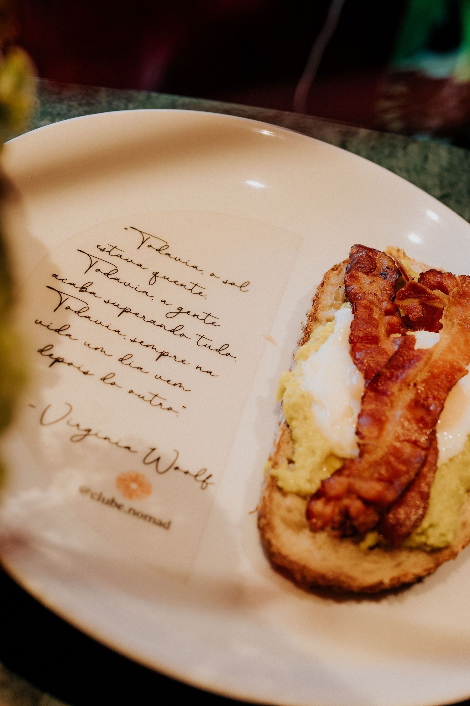 White plate with handwritten text and a small portion of gourmet food.