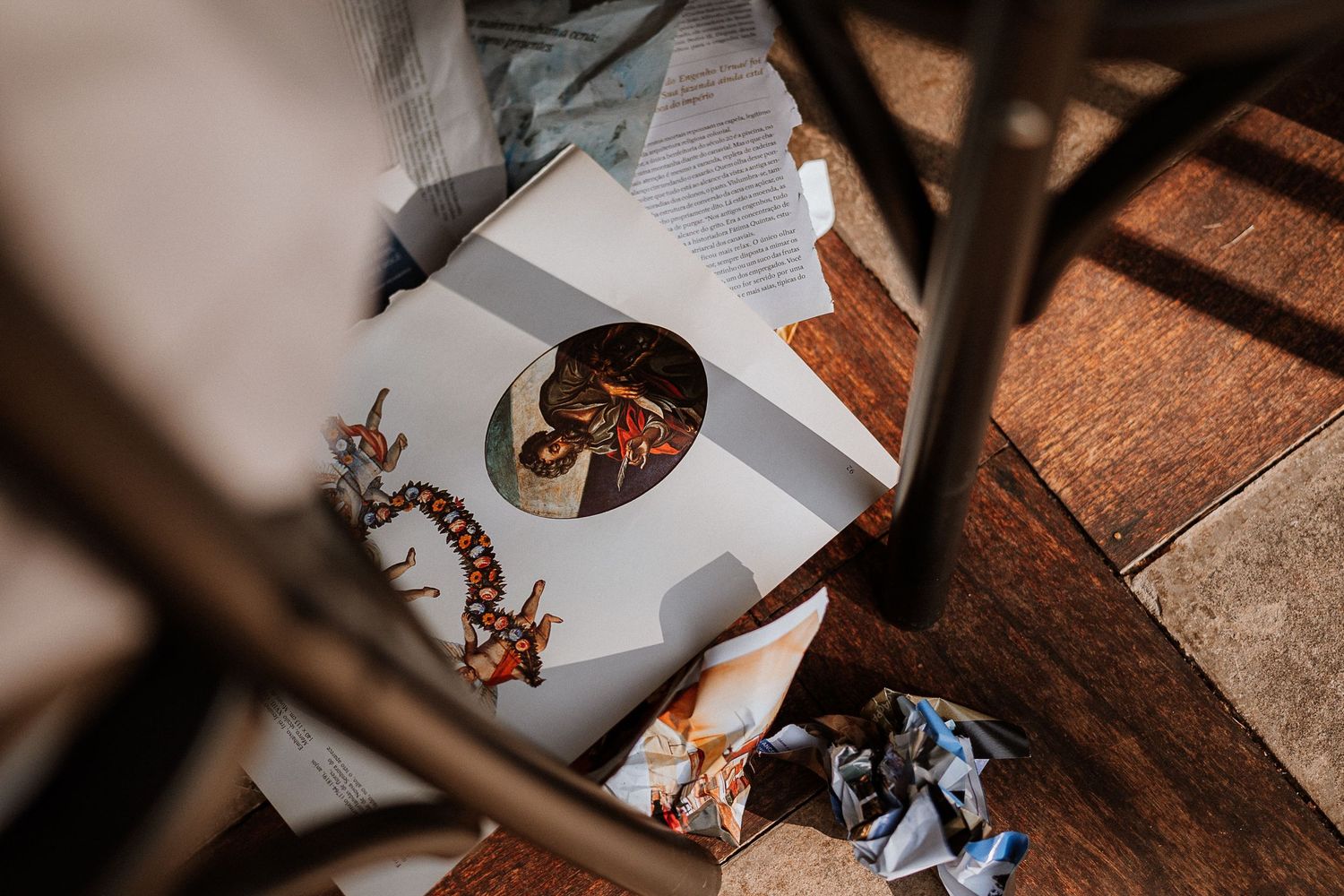 Overhead view of art materials and papers scattered on a wooden surface.