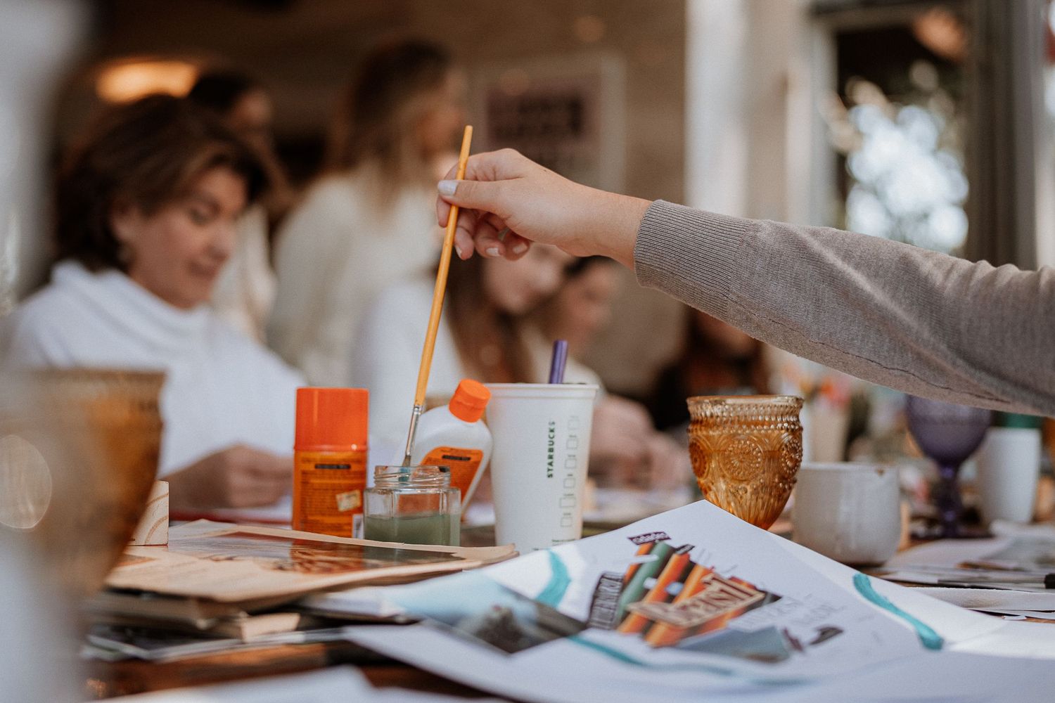 Hands working with art supplies and materials during a creative workshop.