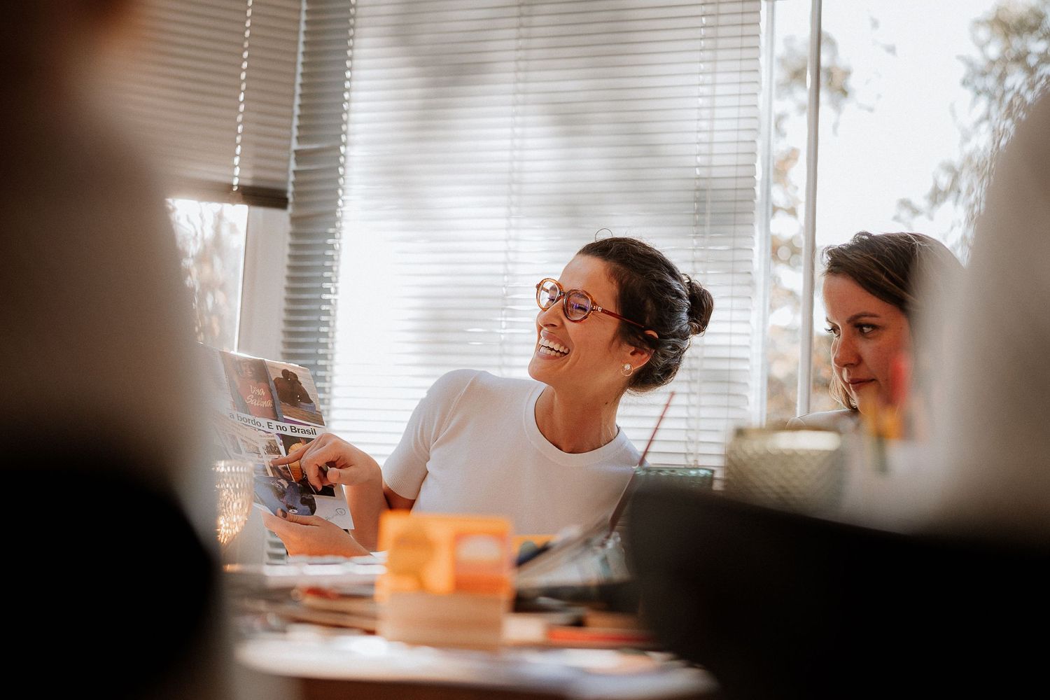 People reviewing documents together in an office setting with natural light from window.