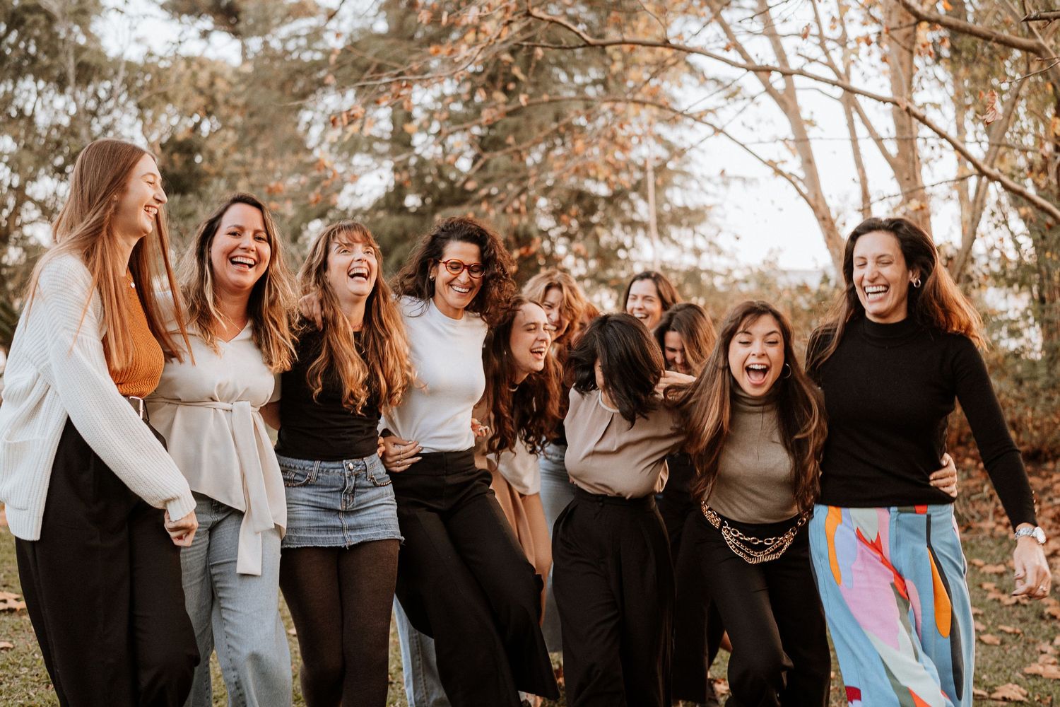 Group posing together outdoors in casual attire during autumn.