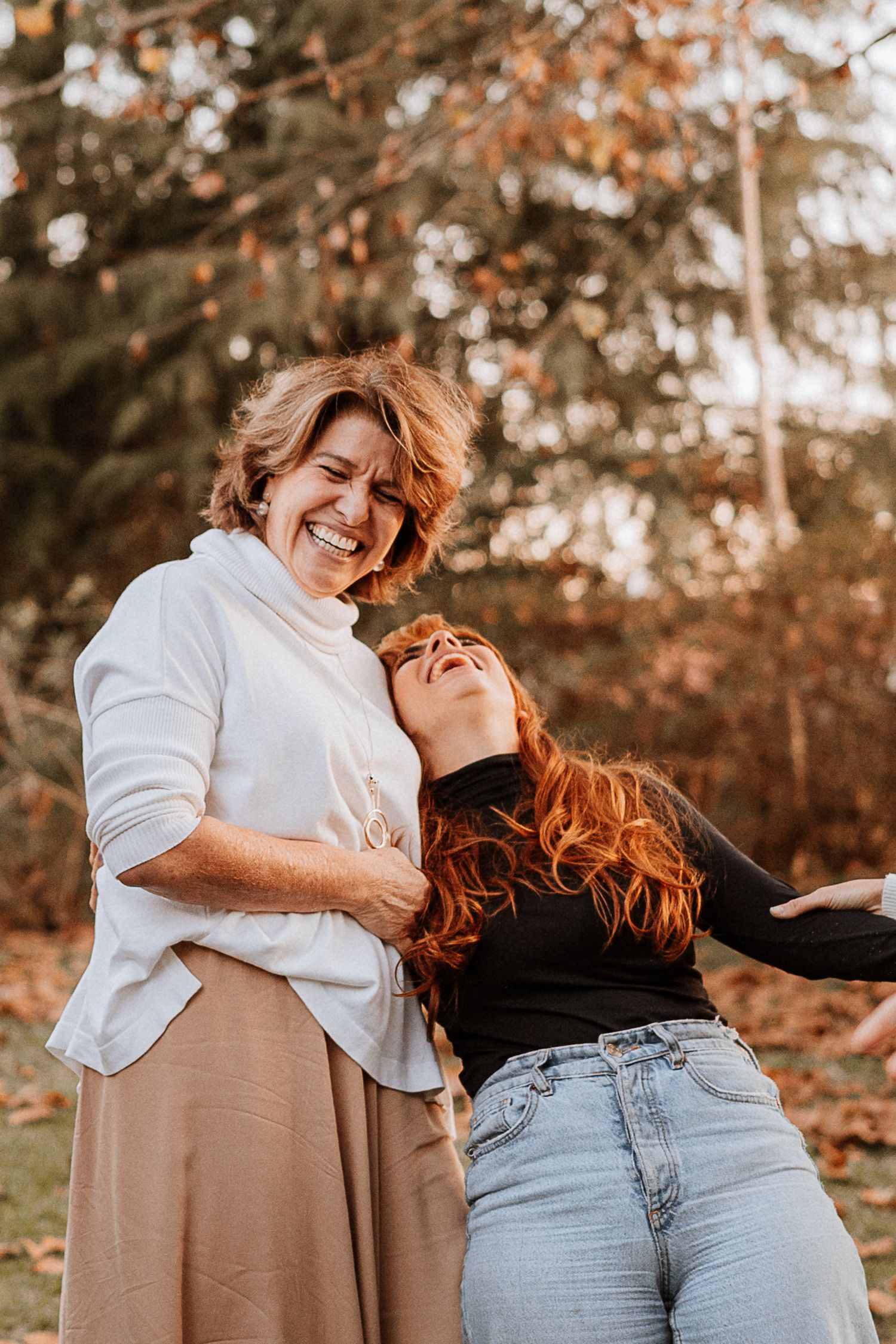 Two people sharing joyful moment together in autumn setting.