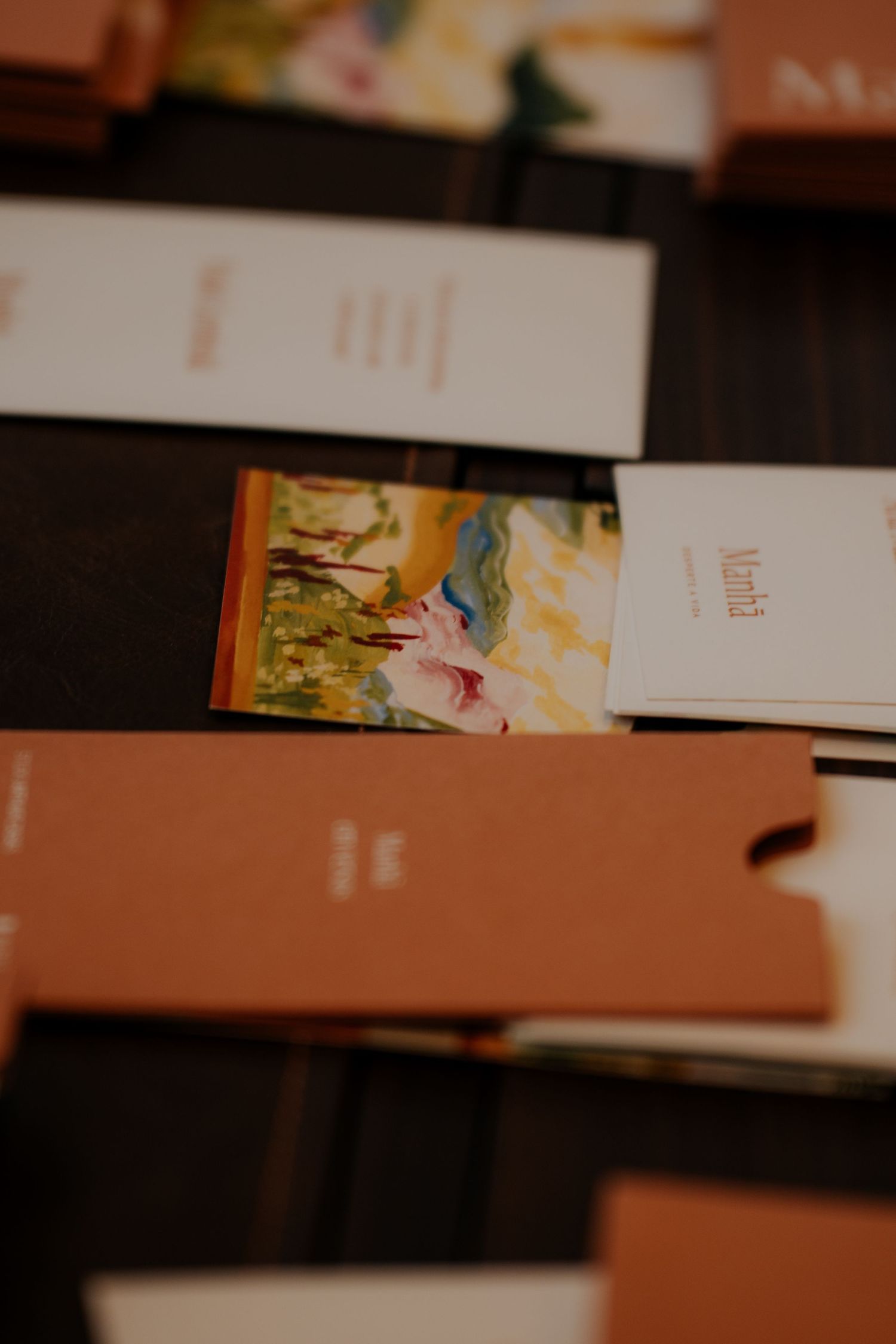Artistic book covers arranged on a dark surface with orange and white color scheme.