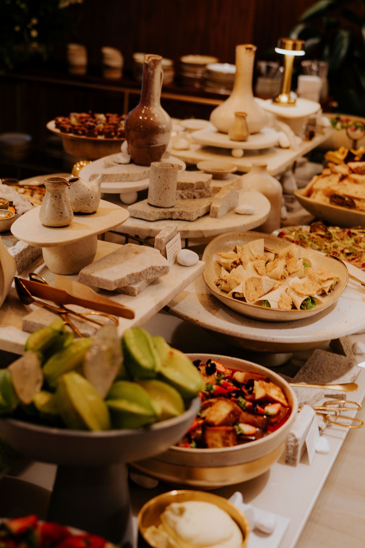 An elegant display of appetizers and snacks on tiered serving platters.