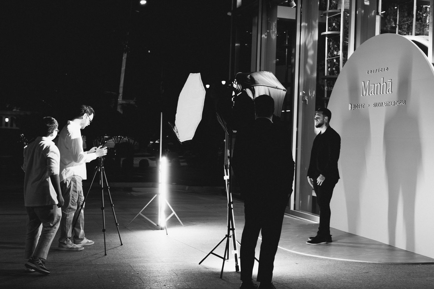 Black and white photo of a photography studio setup with lighting equipment and reflectors.