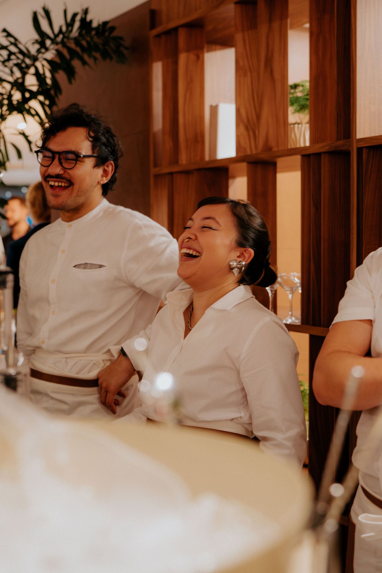Group of people in white uniforms laughing together during a social gathering.