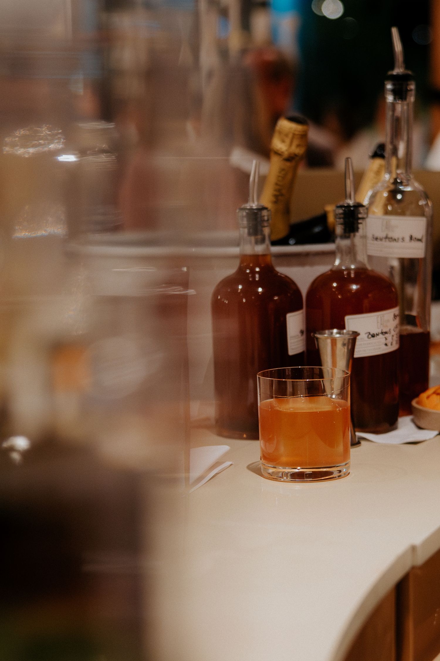 Several liquor bottles arranged on a white surface in soft focus.