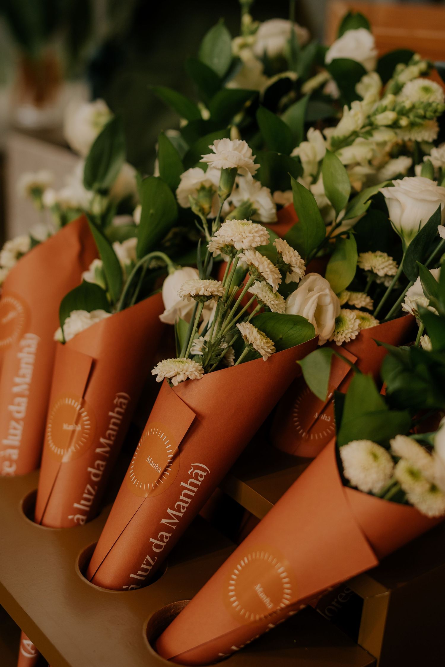 Row of terracotta planters with white flowers arranged in a decorative display.
