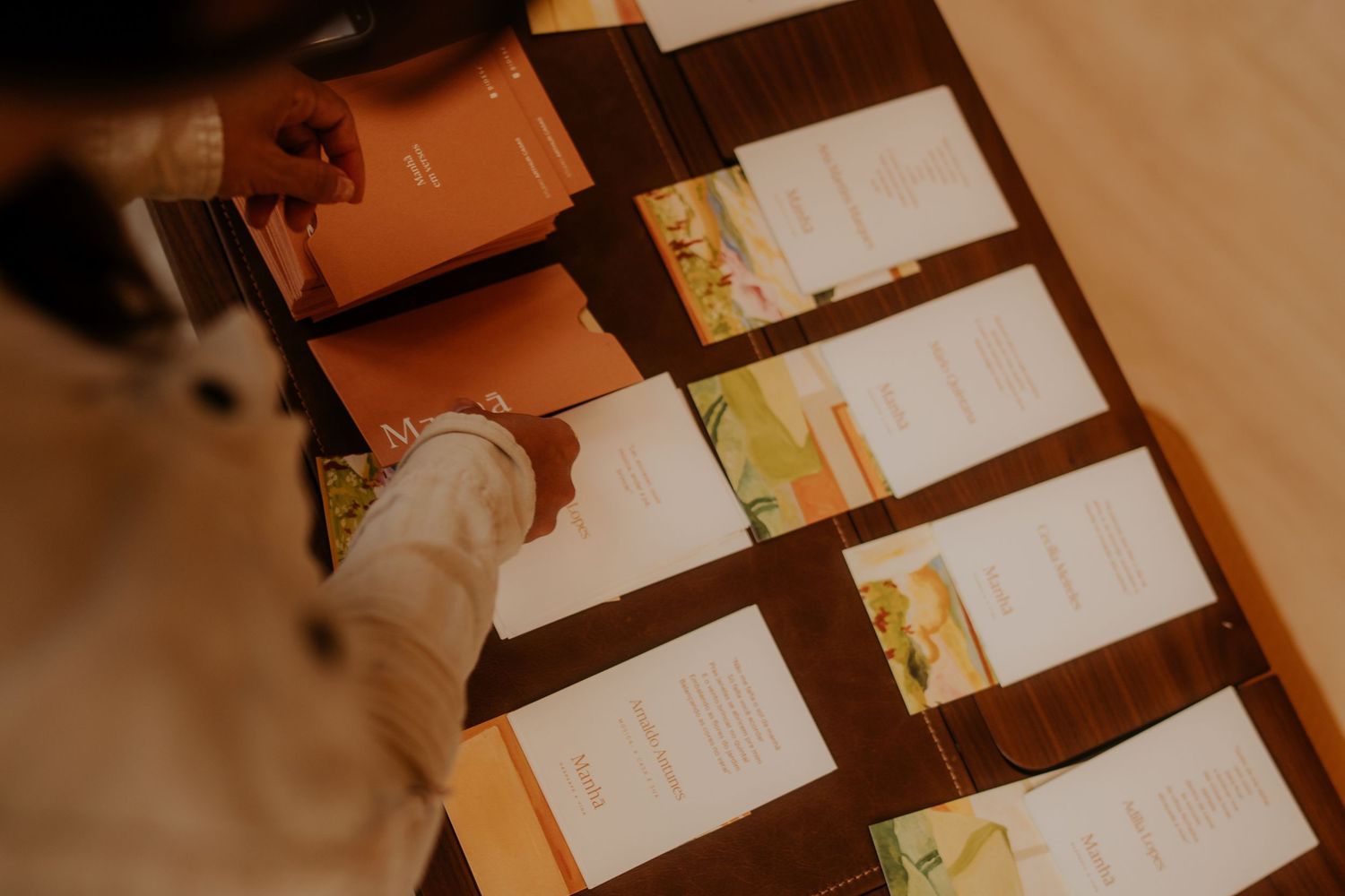 Close-up view of paper cards arranged in a neat row on a wooden surface.