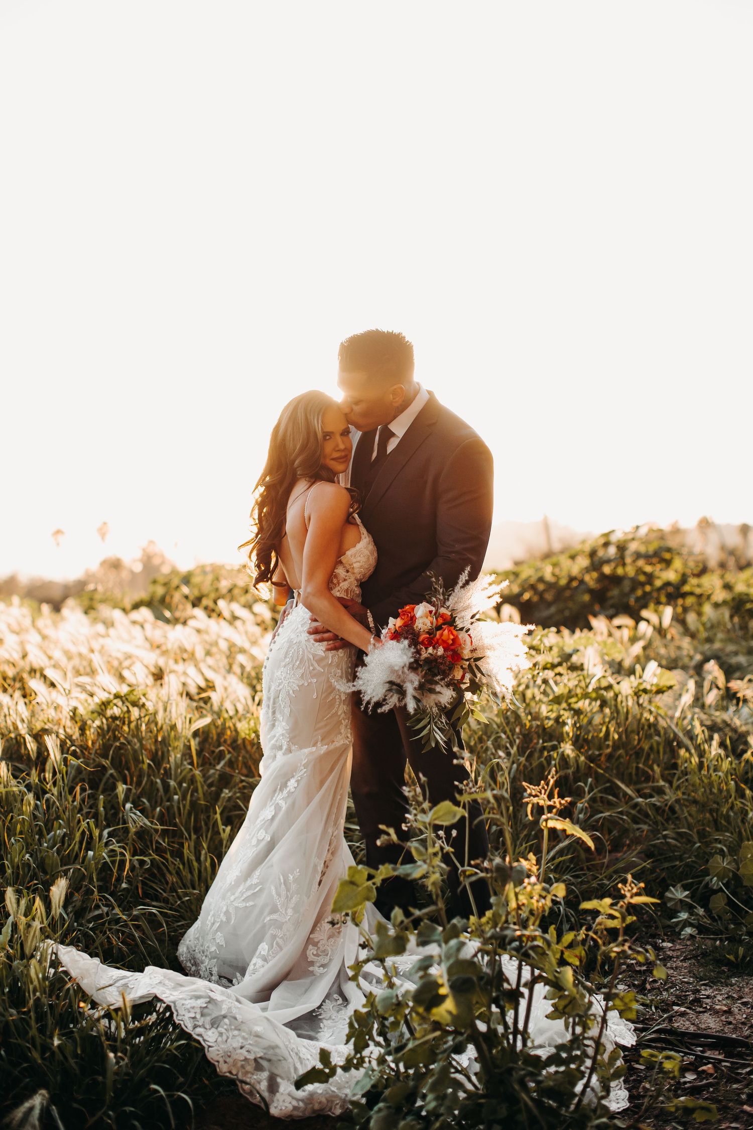A romantic golden hour photography series showing a couple in wedding attire embracing in a sunlit meadow.