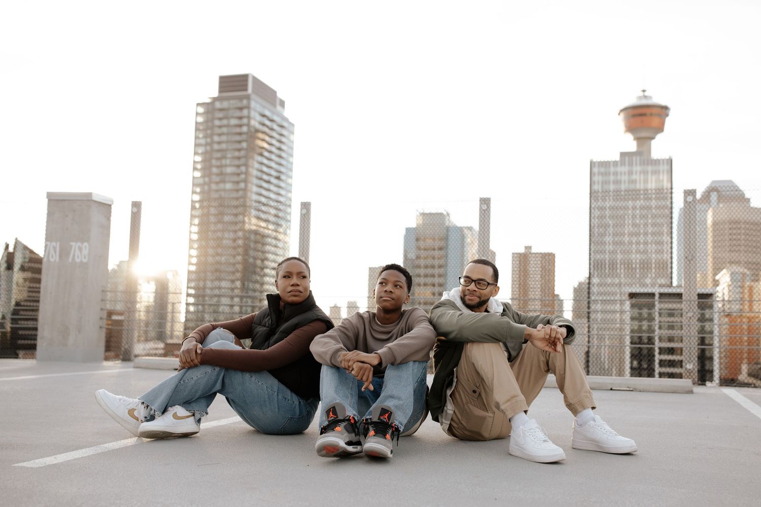 Friends enjoying a casual hangout on an urban rooftop with skyscrapers in the background.