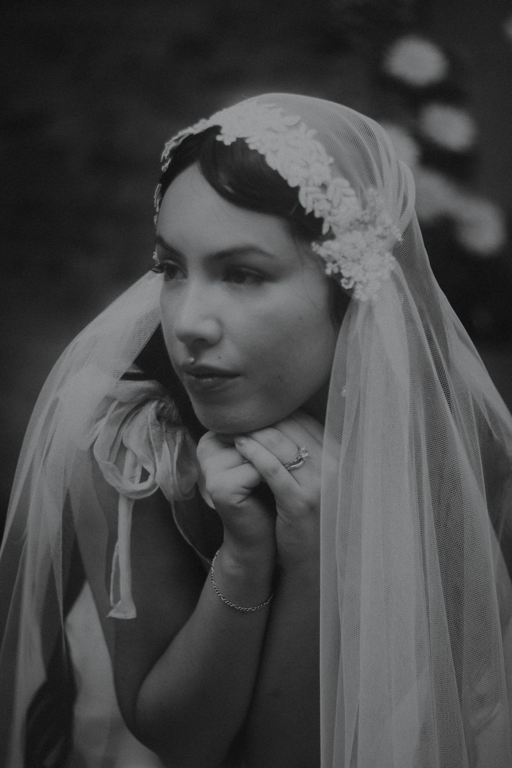 Elegant black and white bridal portrait featuring a detailed lace veil and vintage styling.
