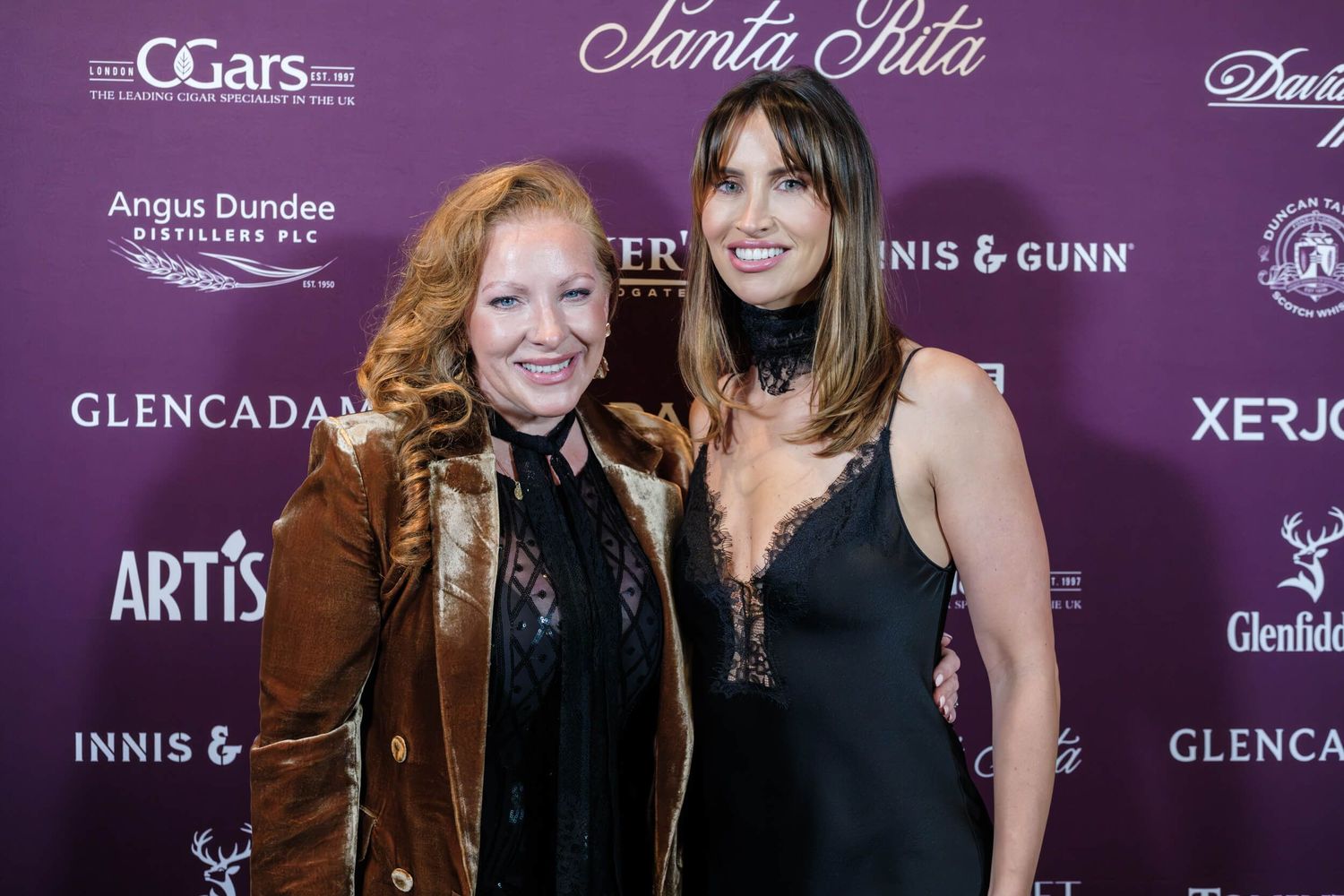 Group of people pose together at an event with purple backdrop featuring CGars and Artis & Gunn logos.
