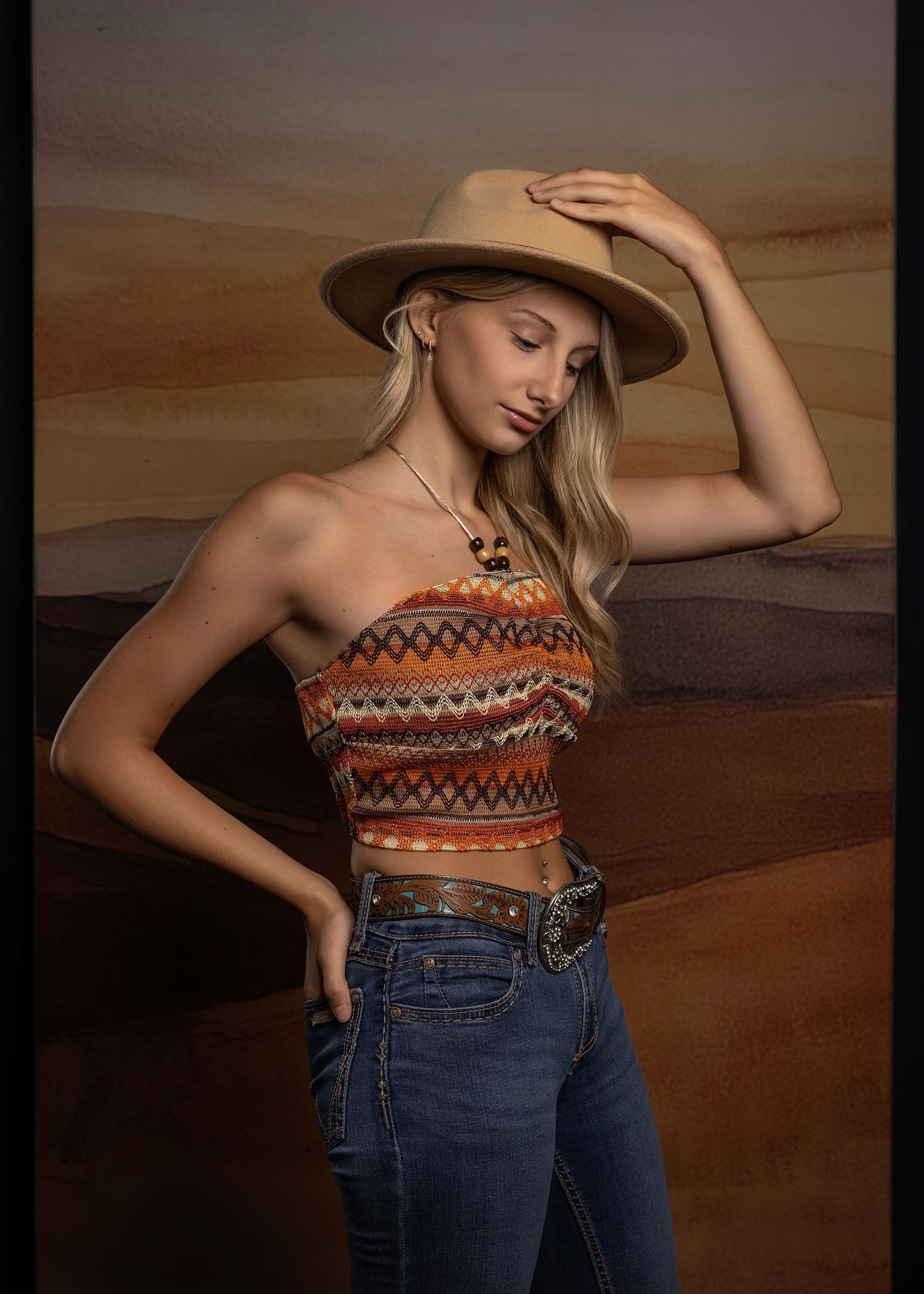 Stylish western-inspired fashion photos with denim and hat against neutral background.