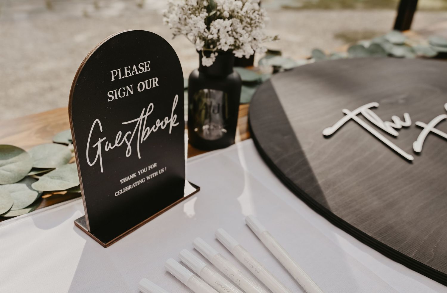 Modern black and white wedding signage displayed on tables.