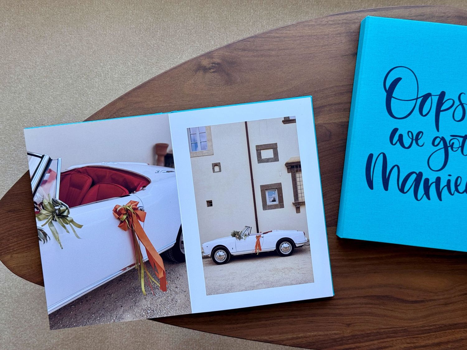 Photos and a bright blue notebook arranged on a wooden surface showing travel memories and personal mementos.