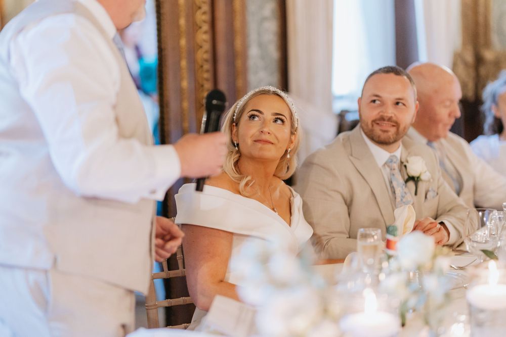 Wedding guests dance and celebrate during a lively reception in an elegant indoor venue.