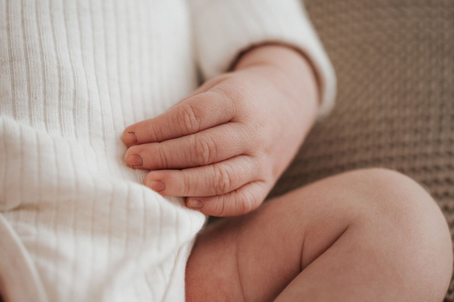 A series of tender close-up shots showing gentle touches and holding hands against soft white backgrounds.