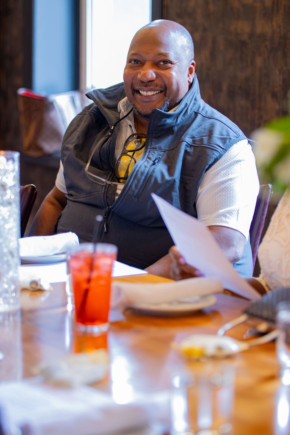 Three sequential photos show someone sitting at a restaurant table, smiling and enjoying a meal with beverages.