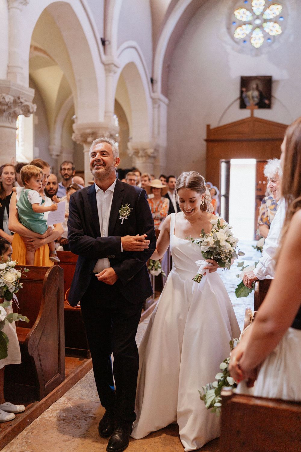 une mariée qui entre à l'église avec son père